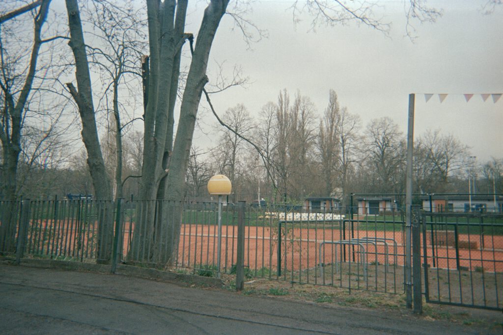 Fotografie eines Tennisplatzes, von außen.